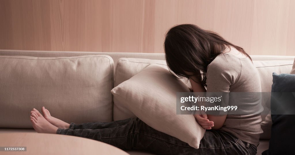 Mujer se siente deprimido en el sofá