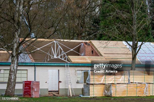 Building fitted with warm pitched roof insulation by installing insulating sandwich panels.