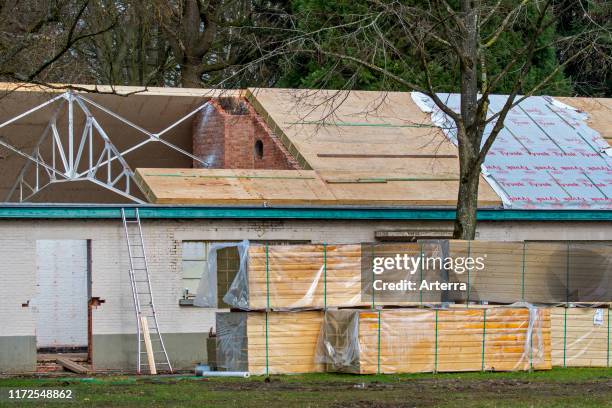 Building fitted with warm pitched roof insulation by installing insulating sandwich panels.