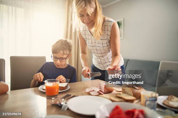 mother and son having breakfast - making a sandwich stock pictures, royalty-free photos & images