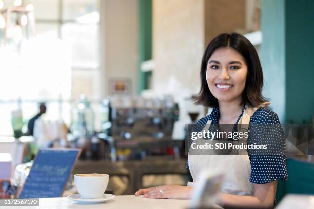 barista waits for customer to pick up coffee order - business people holding menus in restaurant stock pictures, royalty-free photos & images