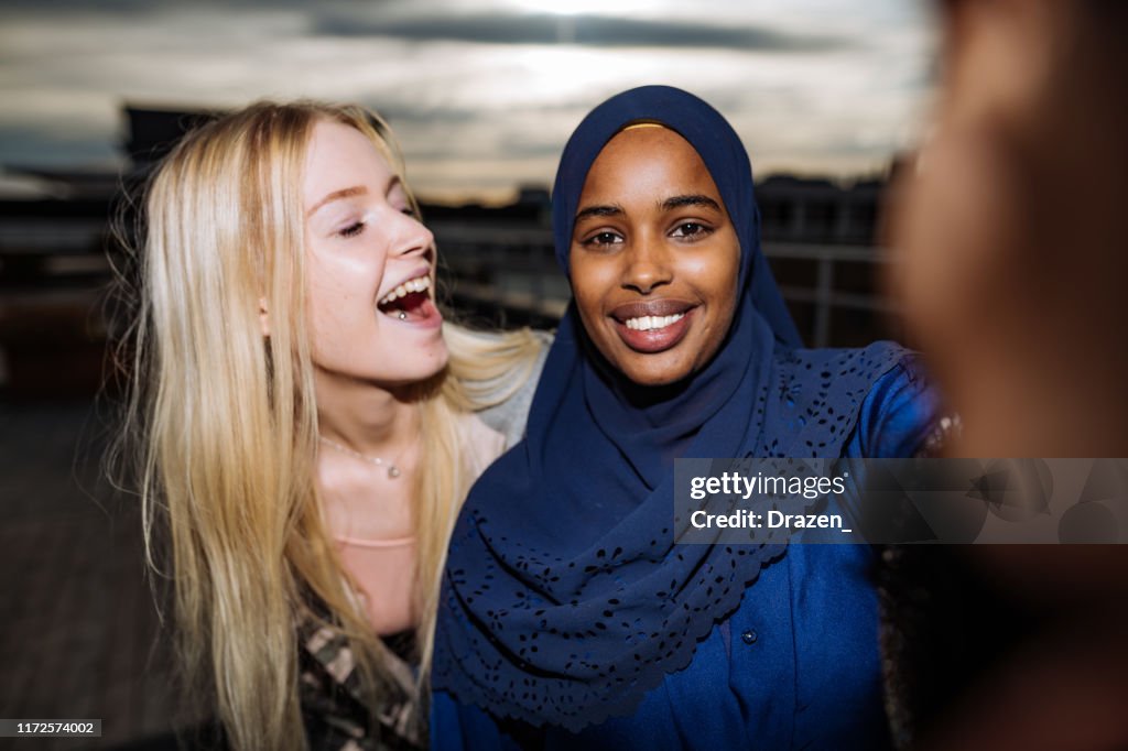 Diverse friends taking selfie and smiling