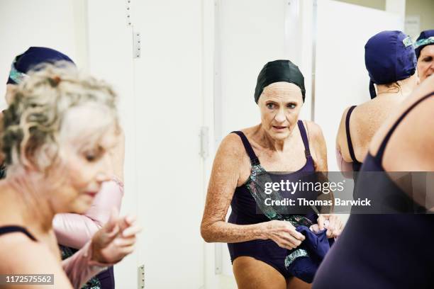 Senior female synchronized swim team getting ready for show in locker room