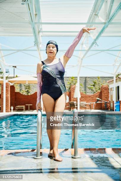 Portrait of smiling senior synchronized swimmer posing after exiting pool