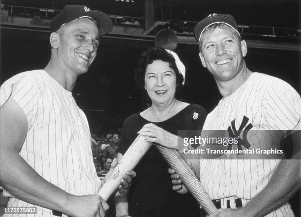 American baseball players Roger Maris and Mickey Mantle , both of the New York Yankees, stand on either side of Claire Ruth before a game at Yankee...