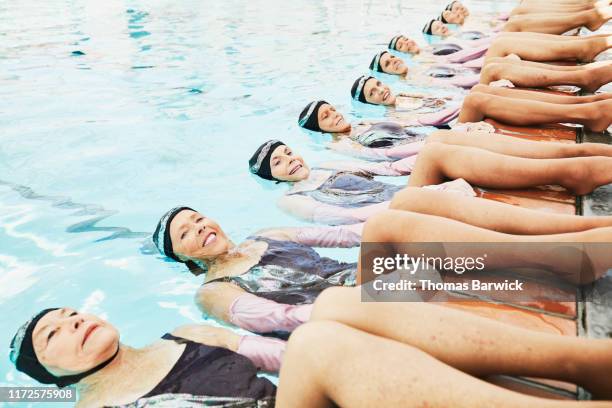 portrait of senior female synchronized swim team on edge of pool - synchronized swimming stockfoto's en -beelden