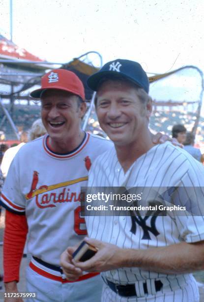 View of retired American baseball players Stan Musial , of the St Louis Cardinals, and Mickey Mantle , of the New York Yankees, as they pose together...