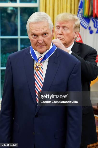 President Donald Trump gives the Presidential Medal of Freedom to National Basket Ball Hall of Fame inductee Jerry West during a ceremony in the Oval...