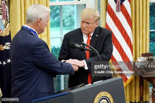 President Donald Trump shakes hands with National Basket Ball Hall of Fame inductee Jerry West after presenting him with the Presidential Medal of...