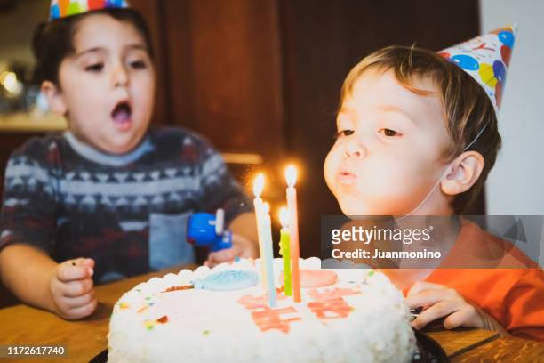 imagem do vintage dos anos setenta, crianças que fundem velas do bolo de aniversário - boys photos - fotografias e filmes do acervo