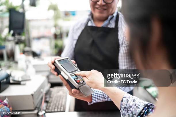 customer putting the password at credit card payment on checkout counter at small business - entering pin stock pictures, royalty-free photos & images