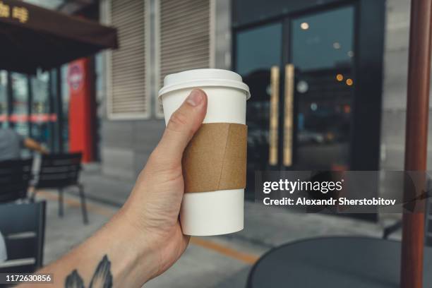 close-up view of paper coffee cup in hand - takeaway coffee cup stock pictures, royalty-free photos & images