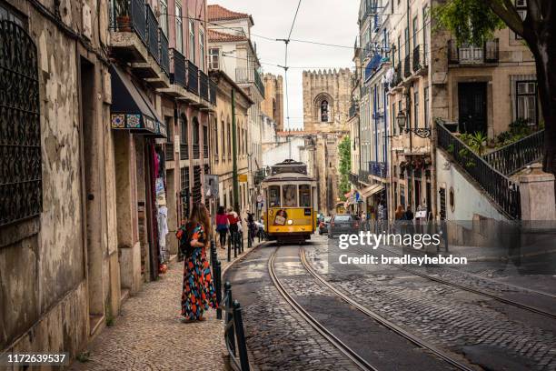 tram 28 transports tourists through alfama district in lisbon, portugal - sé de lisboa imagens e fotografias de stock