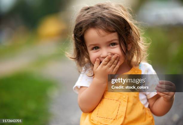 oeps! klein meisje lachen - schattig stockfoto's en -beelden