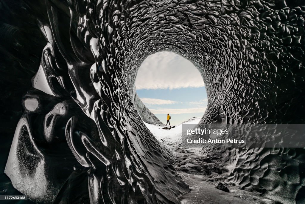 Man exploring an amazing glacial cave in Iceland