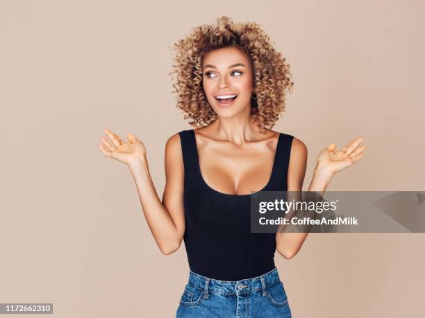 beautiful young woman with curly hair - beautiful woman shocked stock pictures, royalty-free photos & images