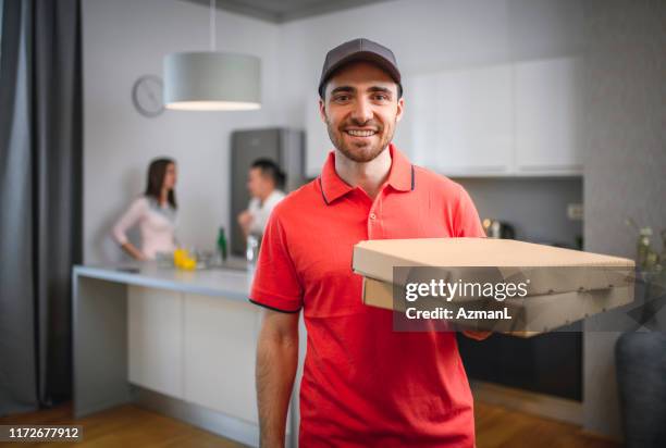 smiling pizza delivery man with boxes for customer - pizza delivery stock pictures, royalty-free photos & images