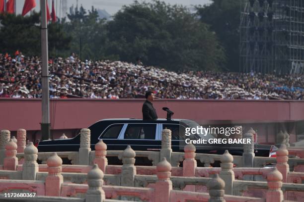 Chinese President Xi Jinping begins a review of troops from a car during a military parade at Tiananmen Square in Beijing on October 1 to mark the...