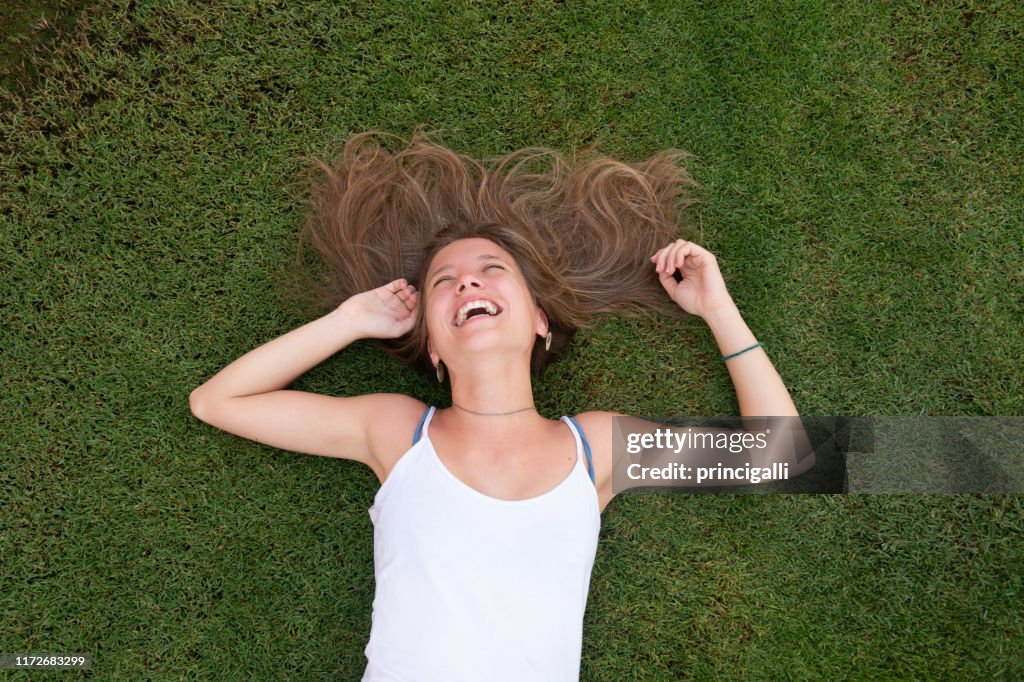 Jeune femme heureux s'étendant sur l'herbe