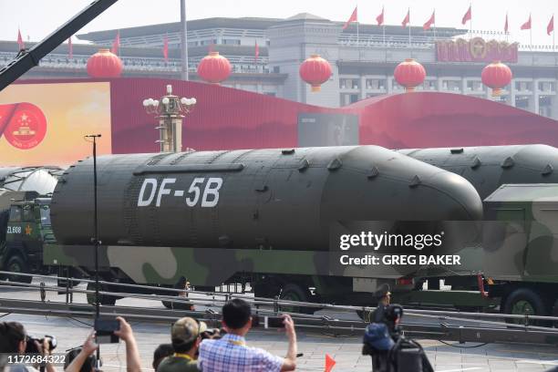 Military vehicles carrying DF-5B intercontinental ballistic missiles participate in a military parade at Tiananmen Square in Beijing on October 1 to...