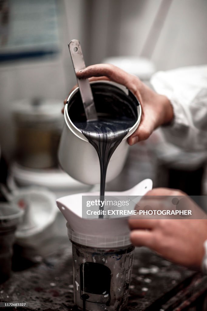 Pouring car paint in a dispersion container using funnel