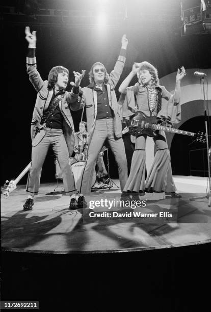 British glam rock band Mud performing on the television music show 'Top Of The Pops', circa 1974. From left to right, bass player Ray Stiles, singer...