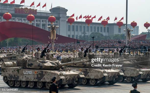 Chinese soldiers sit atop tanks as they drive in a parade to celebrate the 70th Anniversary of the founding of the People's Republic of China in...