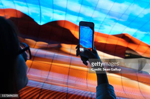 Visitor photographs a display of curved OLED televisions at the LG stand at the 2019 IFA home electronics and appliances trade fair on September 06,...