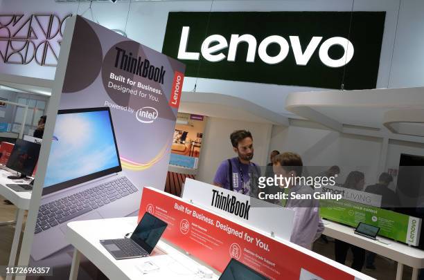 Visitor looks at new laptop computers on display at the Lenovo stand at the 2019 IFA home electronics and appliances trade fair on September 06, 2019...