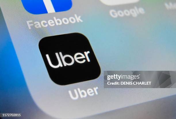 Picture taken on October 1, 2019 shows the logo of Uber app displayed on a tablet screen, in Lille, northern France.