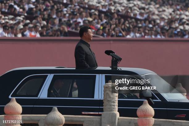 Chinese President Xi Jinping begins a review of troops from a car during a military parade at Tiananmen Square in Beijing on October 1 to mark the...