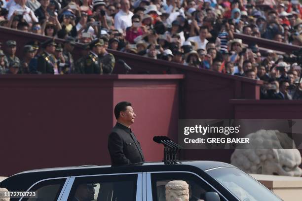 Chinese President Xi Jinping begins a review of troops from a car during a military parade at Tiananmen Square in Beijing on October 1 to mark the...