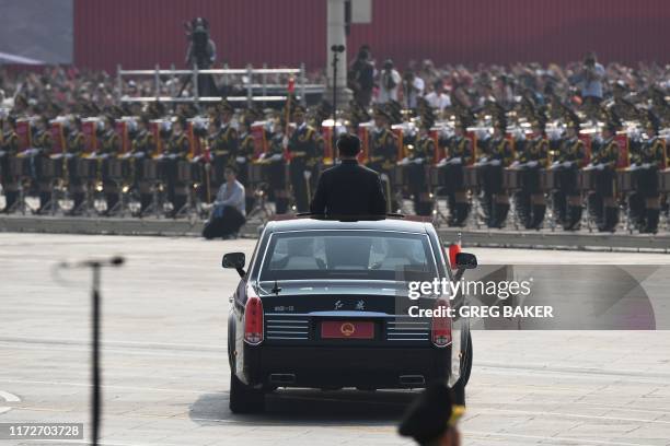 Chinese President Xi Jinping begins a review of troops from a car during a military parade at Tiananmen Square in Beijing on October 1 to mark the...