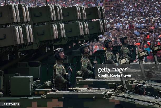Chinese soldiers sit atop mobile rocket launchers as they drive in a parade to celebrate the 70th Anniversary of the founding of the People's...
