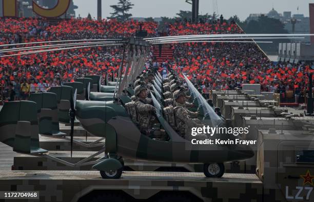 Chinese soldiers sit in small helicopters as they ride on trucks in a parade to celebrate the 70th Anniversary of the founding of the People's...