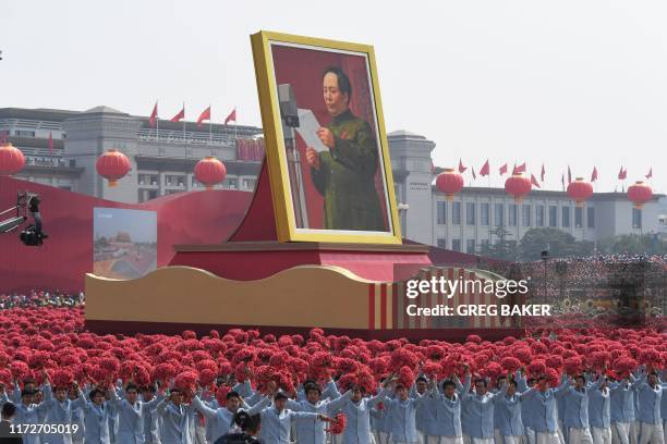 Giant portrait of former Chinese Communist Party leader Mao Zedong passes by Tiananmen Square during the National Day parade in Beijing on October 1...