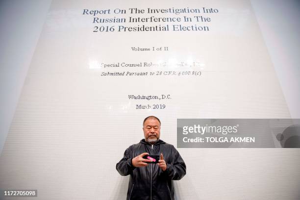 Chinese artist Ai Weiwei poses with his artwork made of lego entitled "The Cover Page of The Muller Report, Submitted to Attorney General William...
