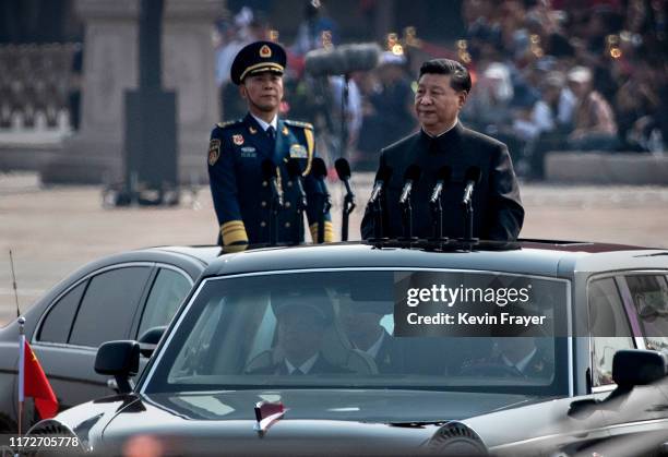 Chinese President Xi Jinping drives in a Hong Qi car after inspecting the troops during a parade to celebrate the 70th Anniversary of the founding of...
