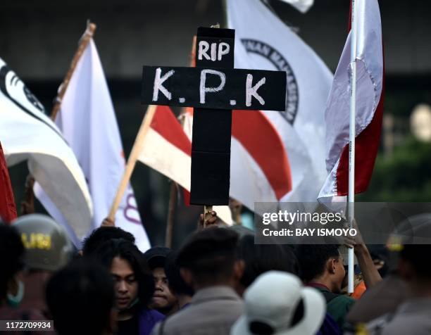 Students hold a placard depicting an epitaph symbolising the death of the country's corruption eradication commission, during a rally in front of the...