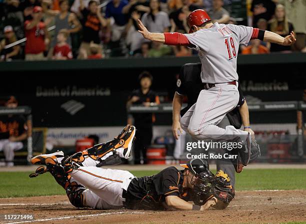 Catcher Matt Wieters of the Baltimore Orioles tags out Joey Votto of the Cincinnati Reds trying to score at home plate for the third out during the...
