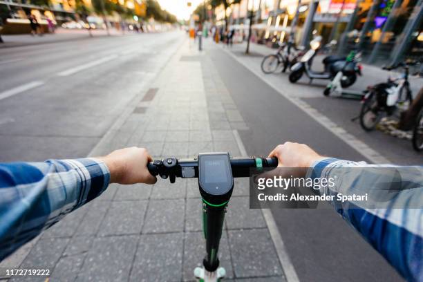 riding electric scooter in the city, personal perspective view - personal perspective stockfoto's en -beelden