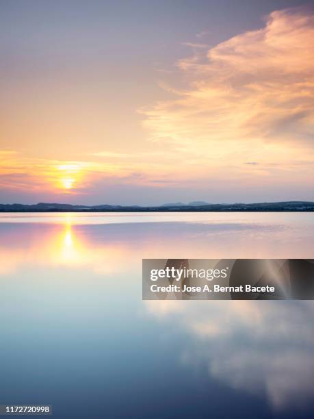 sunset landscape from the shore of a salt lagoon in salt mines of torrevieja, alicante, spain. - alicante spain stock pictures, royalty-free photos & images