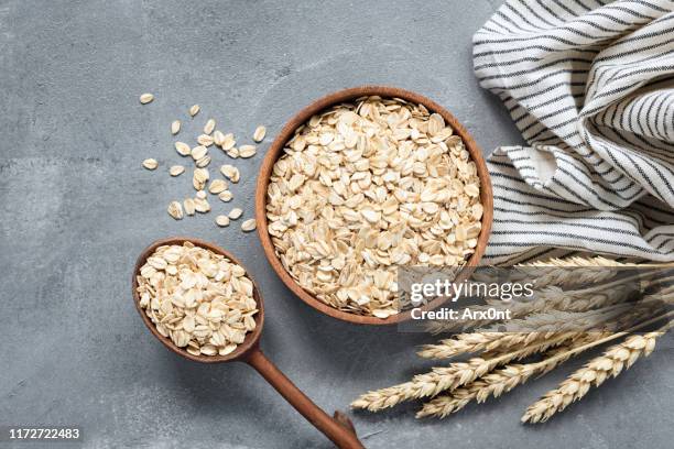 oats, rolled oats or oat flakes in wooden bowl - aveia trilhada imagens e fotografias de stock