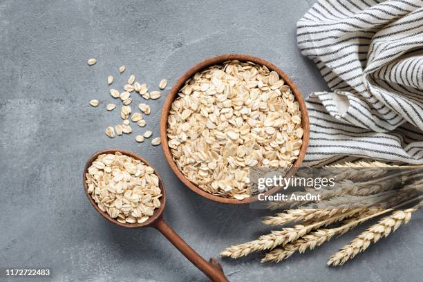 oats, rolled oats or oat flakes in wooden bowl - trigo integral alimento básico - fotografias e filmes do acervo