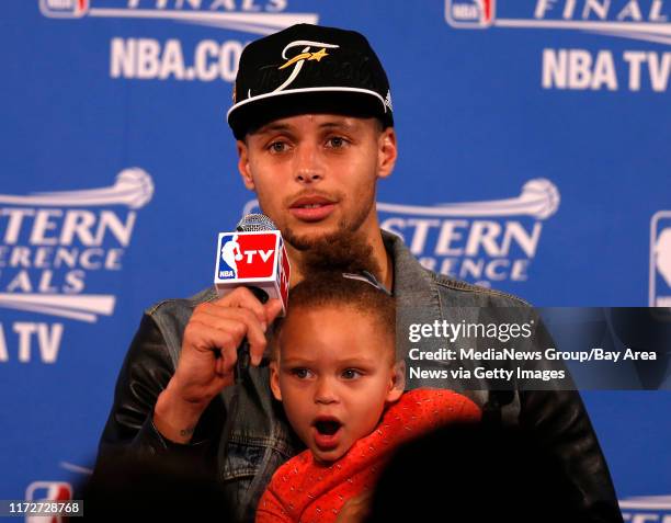 Golden State Warriors' Stephen Curry talks to the media with his daughter Riley after their 104-90 win against the Houston Rockets for Game 5 of the...