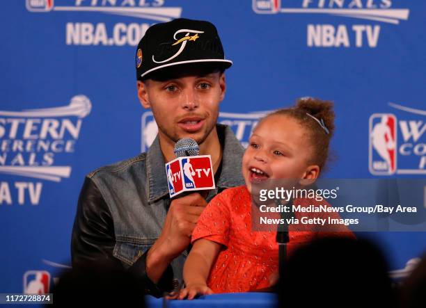 Golden State Warriors' Stephen Curry talks to the media with his daughter Riley after their 104-90 win against the Houston Rockets for Game 5 of the...