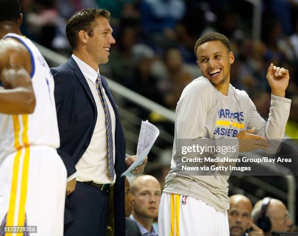 Assistant coach and interim head coach Luke Walton smiles next to Golden State Warriors' Stephen Curry during their game against the Toronto Raptors...