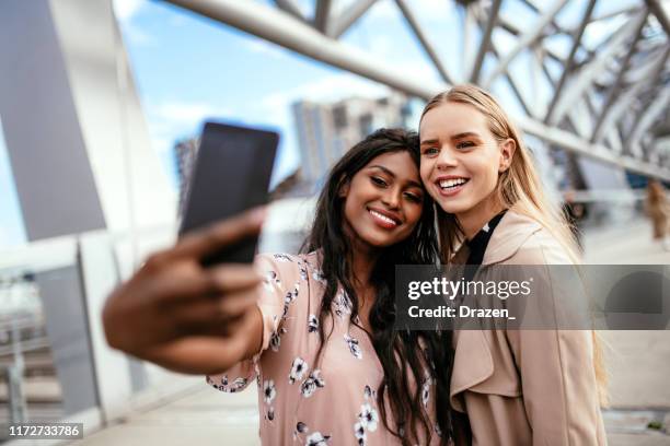 multi ethnic female friends with perfect smiles taking selfie - oslo city life stock pictures, royalty-free photos & images