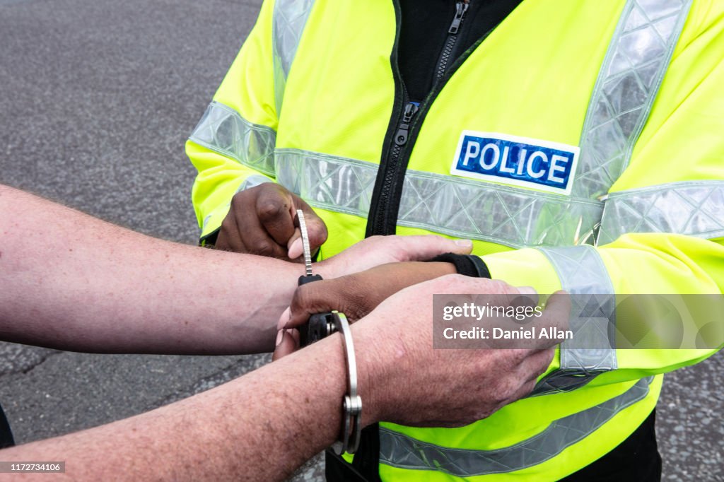 Police women putting on Handcuffs on possible criminal in the street