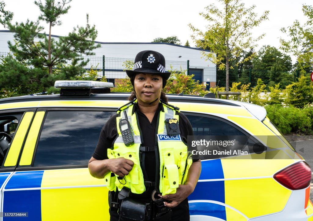 Portrait of Traffic Cop standing by the side of Police car
